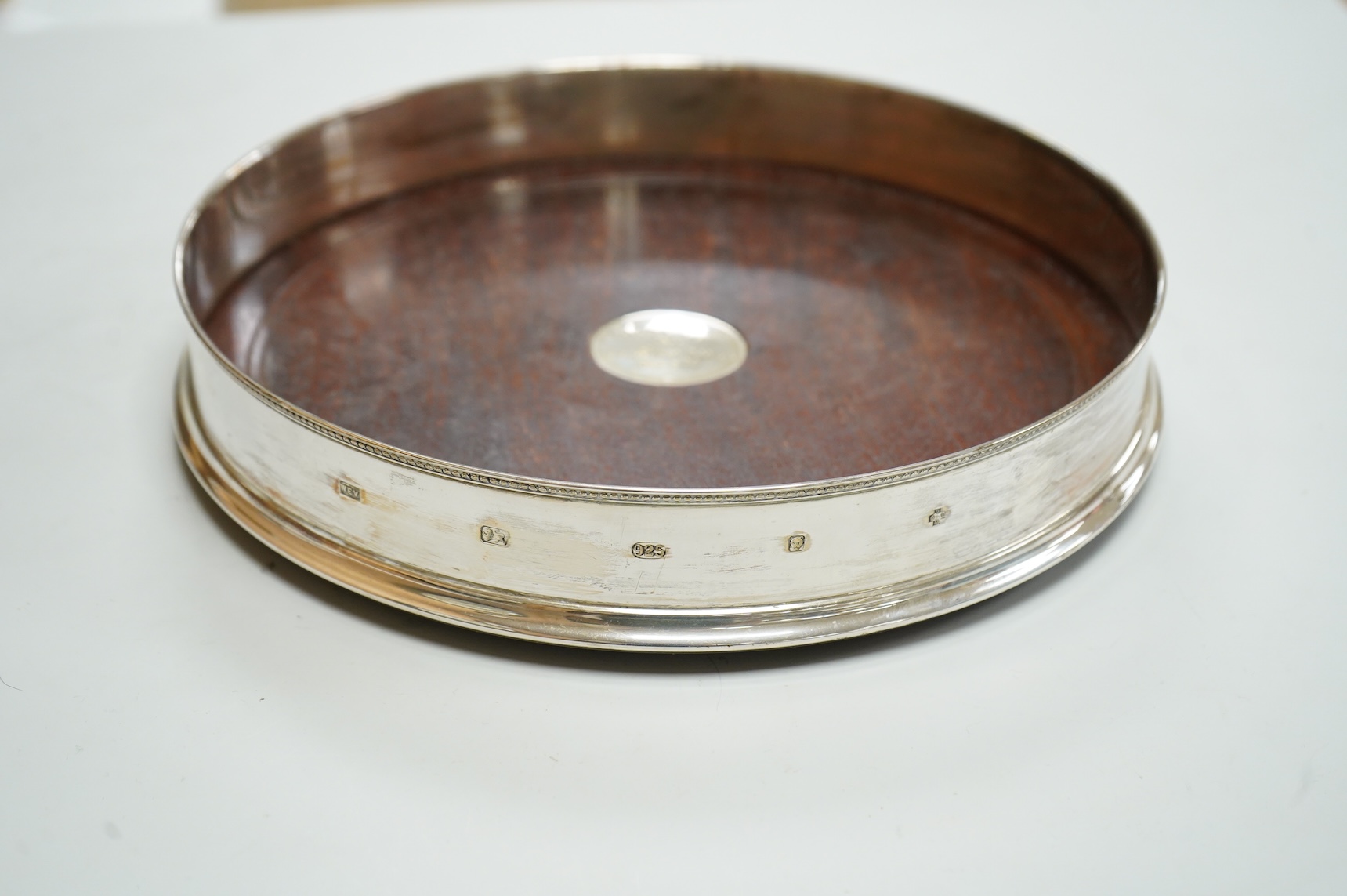 An Elizabeth II large silver mounted decanter coaster, maker W.E.V., London, 2000, with presentation inscription to central boss, diameter 25.6cm.